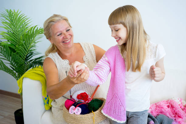 istock Grandmother knitting with granddaughter 882988038