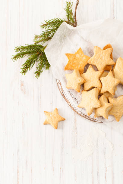 istock Fresh baked biscuits on the baking paper with fir branch on white 882988326