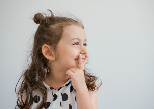 Portrait of a cute happy girl in red t-shirt against white background