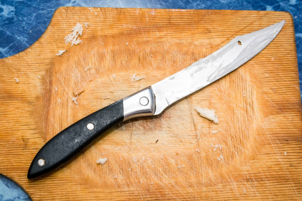 istock Steel kitchen knive on wooden board top view 882993702