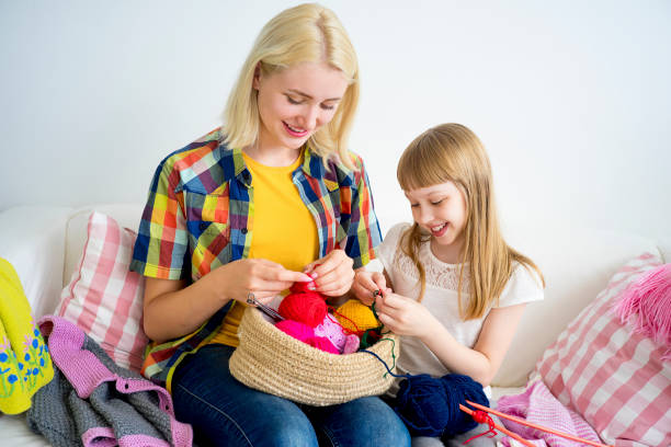istock Girl knitting at home 883005596