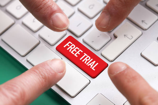 Computer Keyboard Concept: Many fingers pushing red FREE TRIAL keyboard button