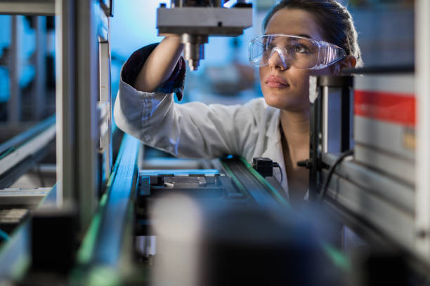 ingegnere donna che esamina la parte della macchina su una linea di produzione. - engineering foto e immagini stock