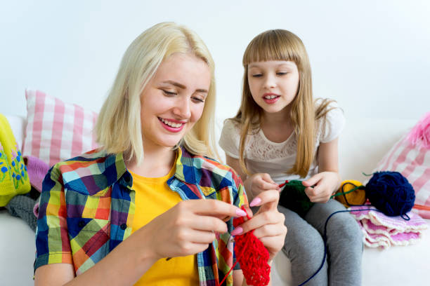 istock Girl knitting at home 883006072