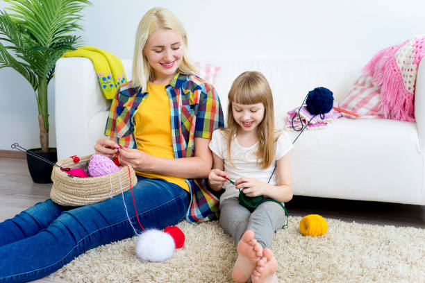 istock Girl knitting at home 883006470