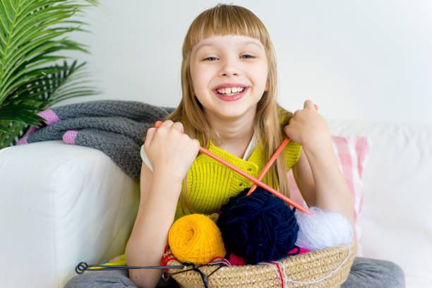 istock Girl knitting at home 883009354
