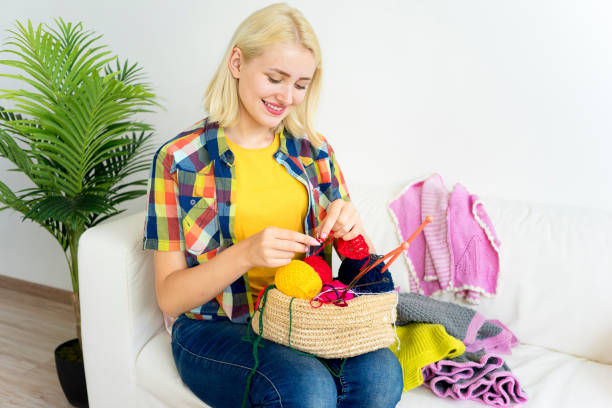 istock Girl knitting at home 883009648