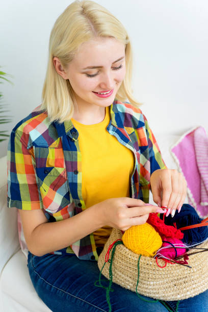 istock Girl knitting at home 883009908