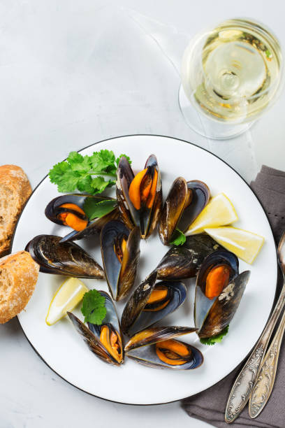 istock Shellfish mussels with white wine, seafood on a table 883019190