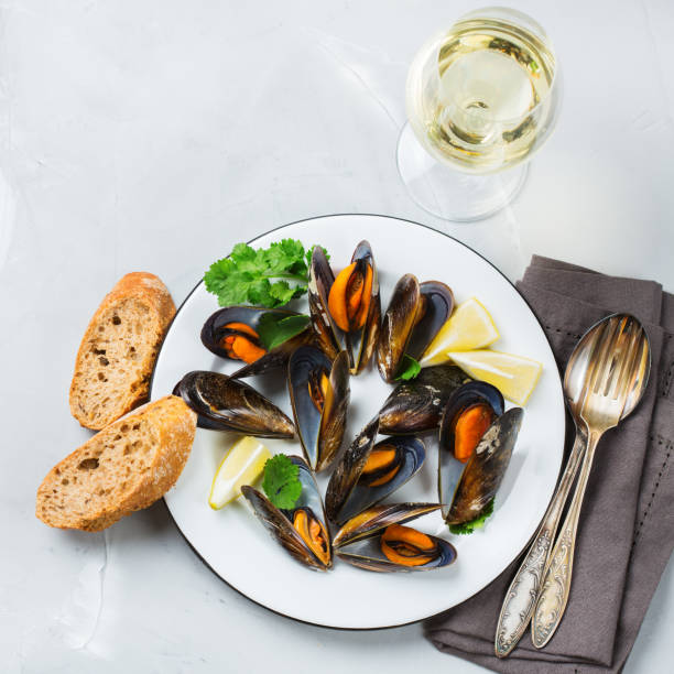 istock Shellfish mussels with white wine, seafood on a table 883020046