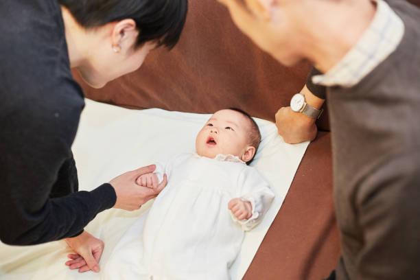 istock mother and father cheering up their baby 883020234