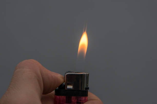 istock male hand holding a plastic gasoline lighter with lighter flame 883027464