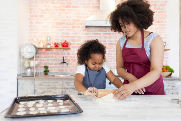 istock Mother and daughter preparing dough for homemade biscuits 883027606