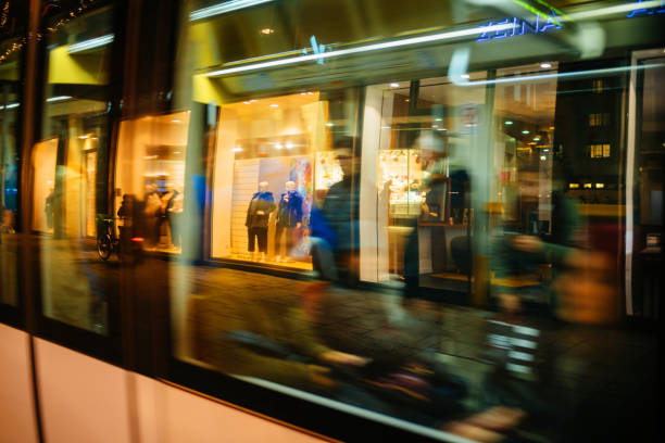 Strasbourg: Shop displays and Christmas light decorations reflected in tramway passing by at night in Strasbourg