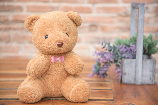 istock Teddy Bear on Wood, Background, Old Brick Wall 883030732