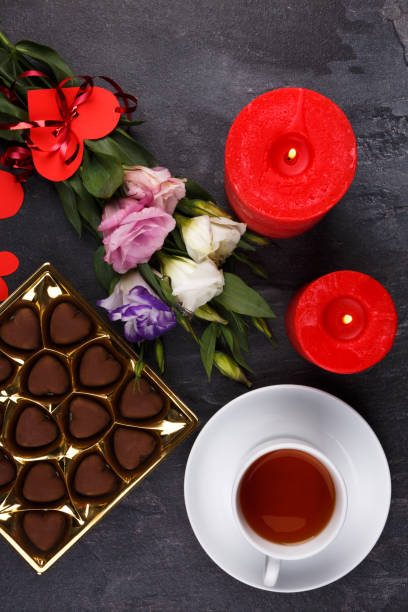 istock A cup of tea with a box of sweets showing not completely on a stone background 883038352