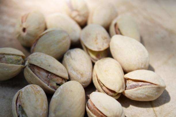 istock Salted pistachios on wooden board 883042360