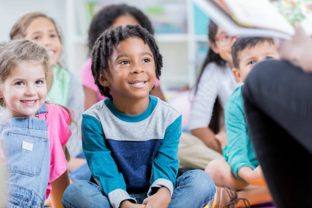 istock Attentive little boy sits on floor during story time 883044672
