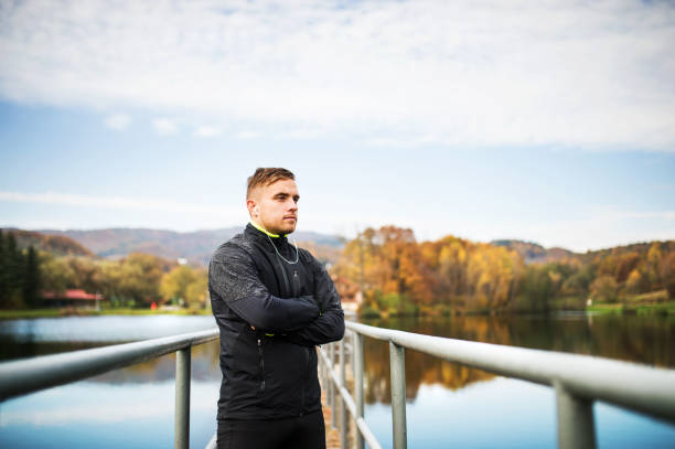 istock Young man in autumn park standing on pier. 883048468