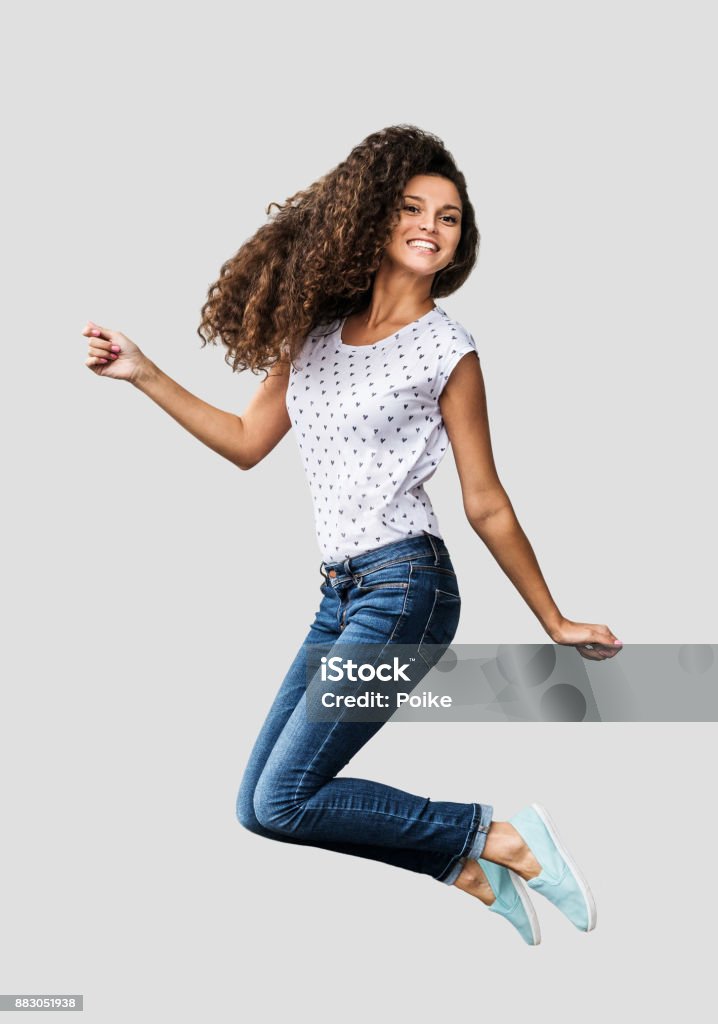 Beautiful emotional woman is jumping and having fun Beautiful girl dancing and enjoying life Jumping Stock Photo