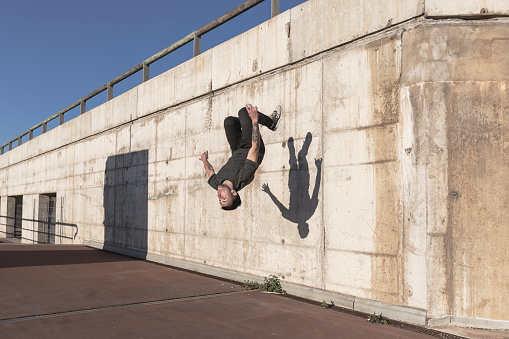 Young man practicing free running in the city