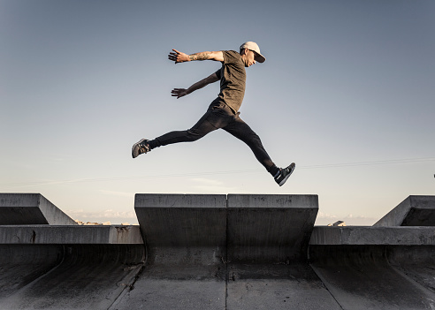 Young man practicing free running in the city