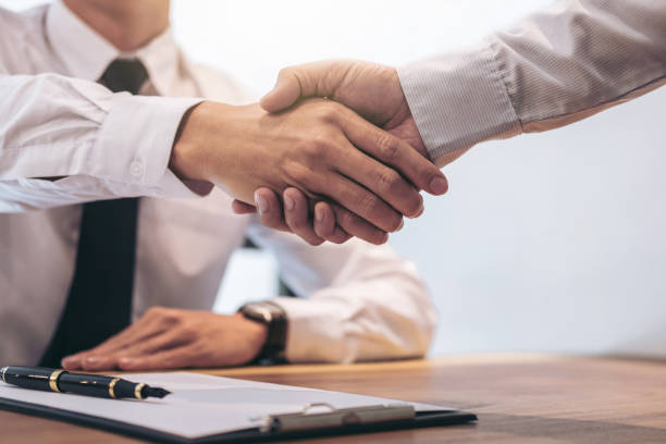istock Real estate broker agent and customer shaking hands after signing contract documents for realty purchase, Bank employees congratulate, Concept mortgage loan approval 883061246