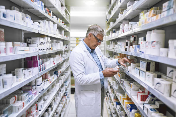 This stuff works wonders Shot of a focused mature male pharmacist making notes of the medication stock on the shelves in a pharmacy antibiotic stock pictures, royalty-free photos & images