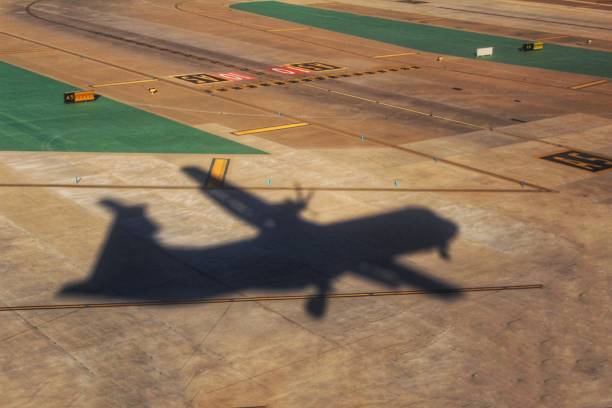istock Shadow of a plane landing 883073502