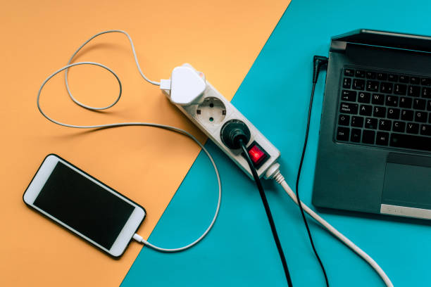 Smartphone and laptop being charged An smartphone and a laptop being charged. battery charger photos stock pictures, royalty-free photos & images