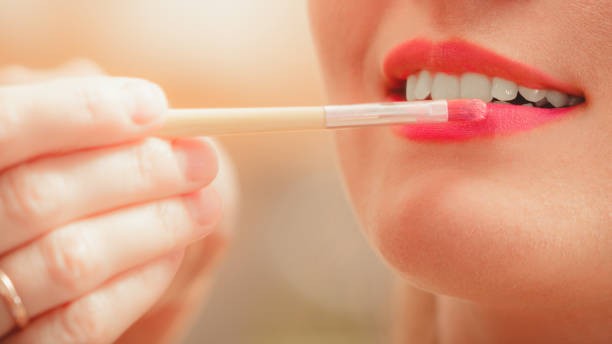 istock Make up artist applying lipstick with brush. 883076154