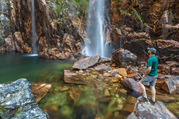 istock Man looking to Parida Waterfall (Cachoeira da Parida) - Serra da Canastra National Park - Brazil 883088156