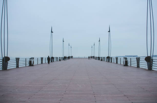 Pier on the Baku Boulevard near Milli Park. Baku, Azerbaijan - December 25, 2016:  View on the Caspian Sea. National Park in Baku in the gray winter day. baku national park stock pictures, royalty-free photos & images