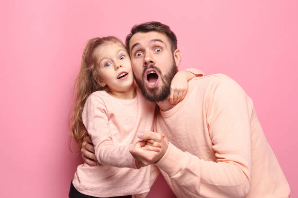 istock Surprised young family looking at camera on pink 883091314