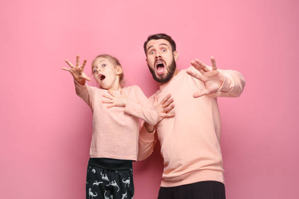 istock Surprised young family looking at camera on pink 883091764