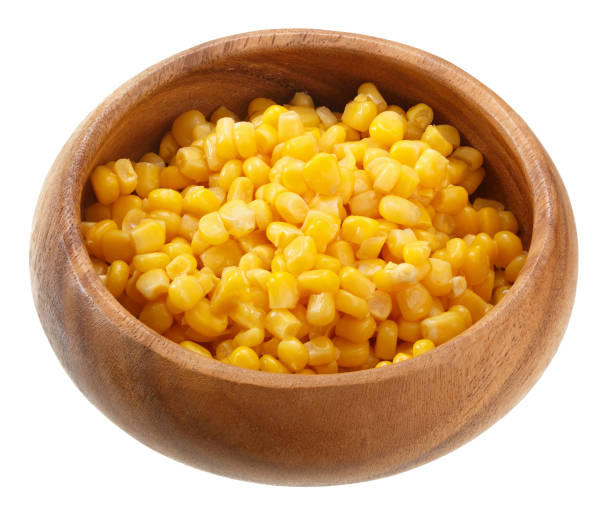 istock Corn seeds in a wooden bowl isolated on white background. Top view. 883092152