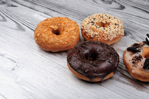 istock Fresh  donuts in soft colorful glaze on  silver  wooden background 883095362