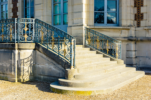 Sceaux, France - November 26, 2017: The garden side staircase of the Sceaux castle  with its wrought iron railing, by a sunny morning.