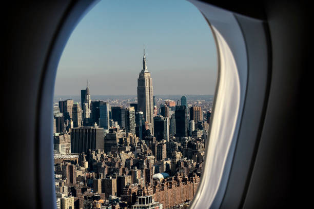 istock Empire State Building in New York City through airplane's window 883106292