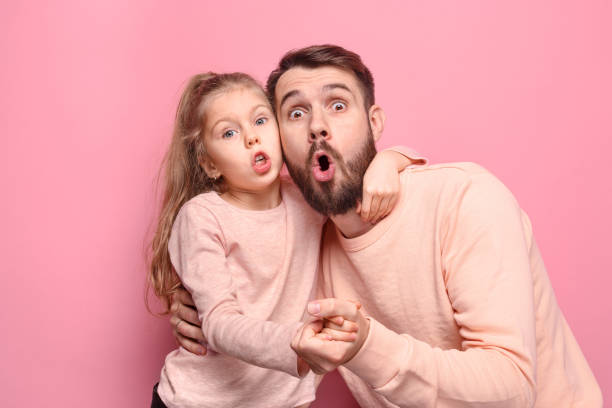 istock Surprised young family looking at camera on pink 883110496