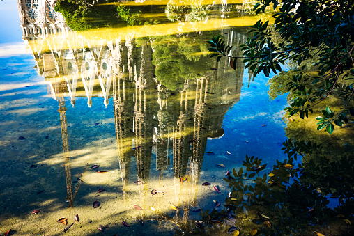 Sagrada Familia, the famous cathedral in Barcelona, refleted in a pond.