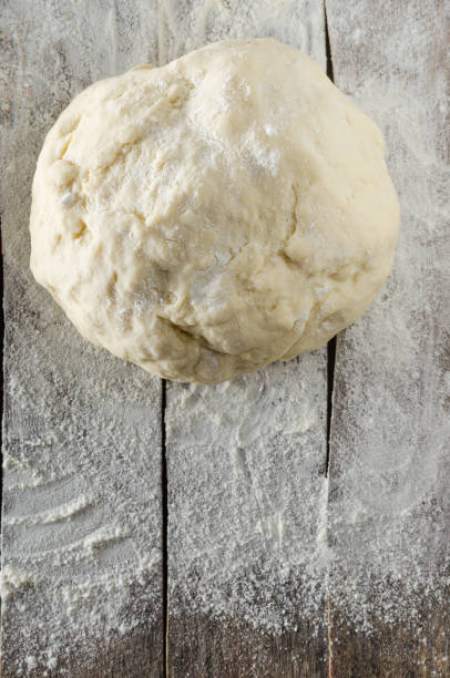 istock Kneaded dough on the table sprinkled with flour 883110986