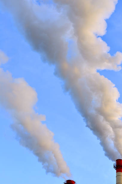 istock Pollution air. Smoke from pipe against blue sky 883125974