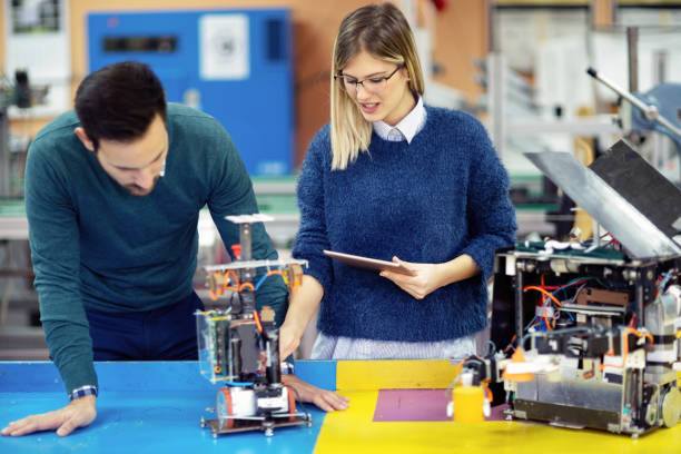 istock Young attractive students of mechatronics working on project 883130226