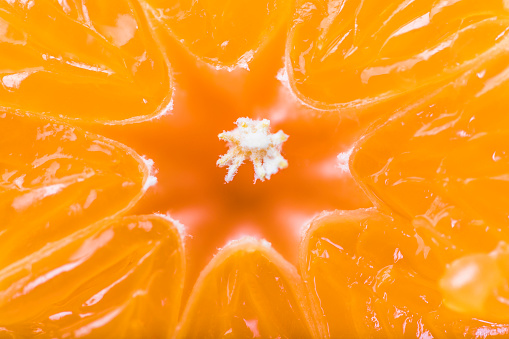 Close-up of the midsection of a tangerine. The  centre is formed like a star. The beauty of nature in abstract patterns.