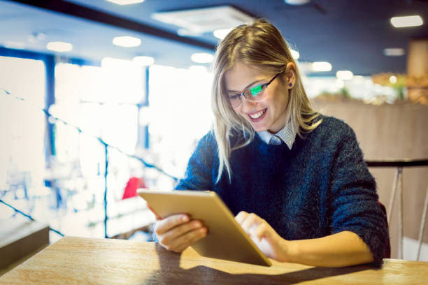 istock Happy young woman drinking coffee and using tablet 883133006