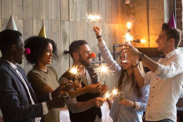 istock Multi-ethnic people holding sparklers and glasses celebrating Ne 883147088