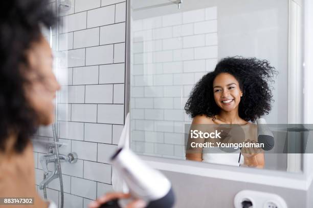 Lächelnde Frau Hält Eine Haar Trockner Blick Auf Spiegel Auf Ihren Wehenden Haaren Stockfoto und mehr Bilder von Badezimmer