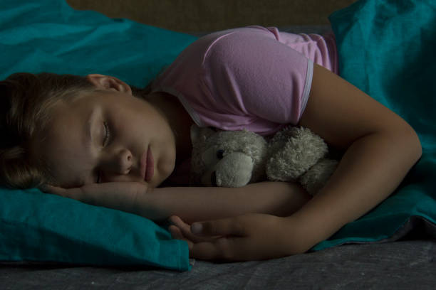 istock Little blond child sleeping in his bed with toy. 883154300
