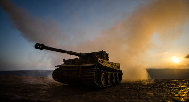 戦争の概念。軍隊は戦争の霧空の背景、夕暮れ時の曇りスカイライン次世界大戦兵士のシルエットに戦闘シーンをシルエットします。装甲車両。ドイツのタンク内のアクション - fire power ストックフォトと画像